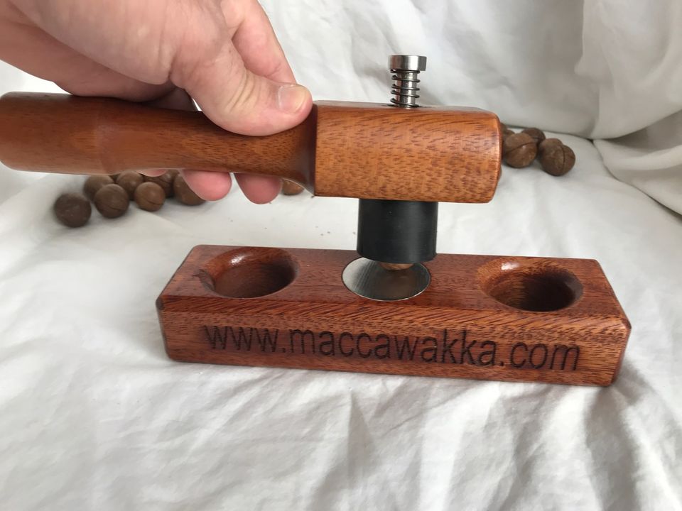 The MaccaWakka macadamia nut cracker: timber base with two cups, stainless steel pin and timber hammer, with macadamias